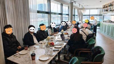 从长桌另一头看过去，一整排人沿着窗坐开