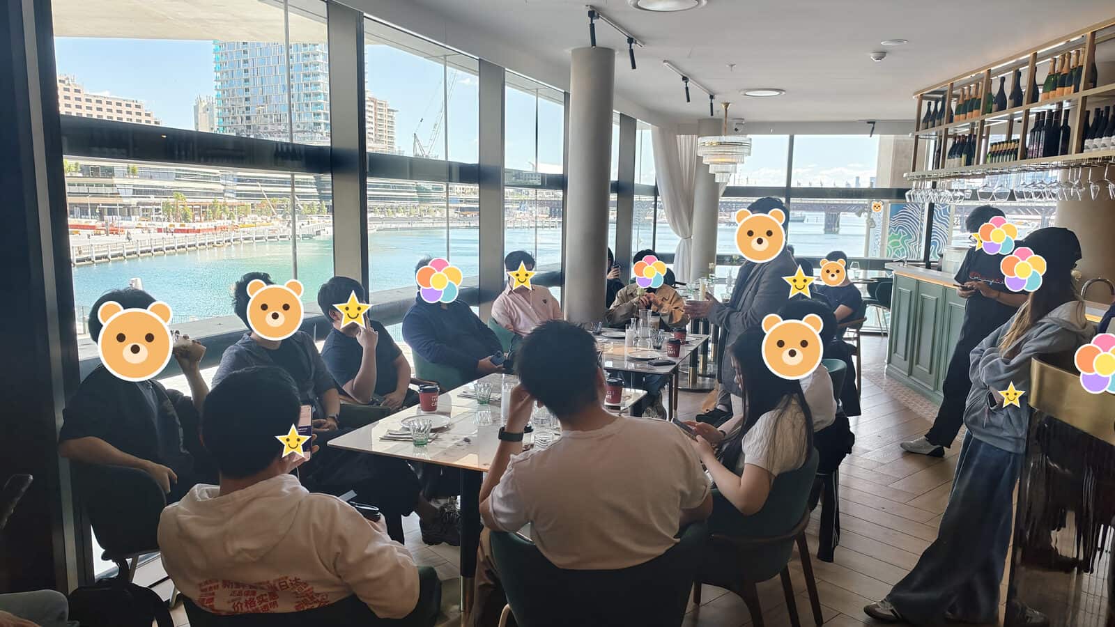 有人站在桌边说话,其余人围坐着听