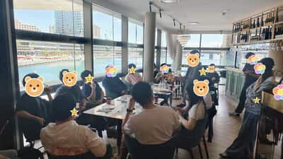 有人站在桌边说话，其余人围坐着听