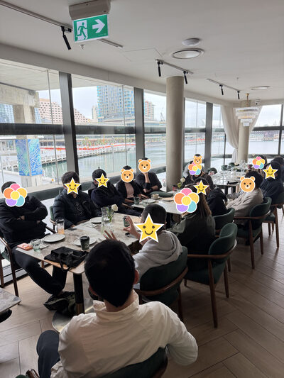 长桌的另一个角度，柱子和落地窗，有人在说话