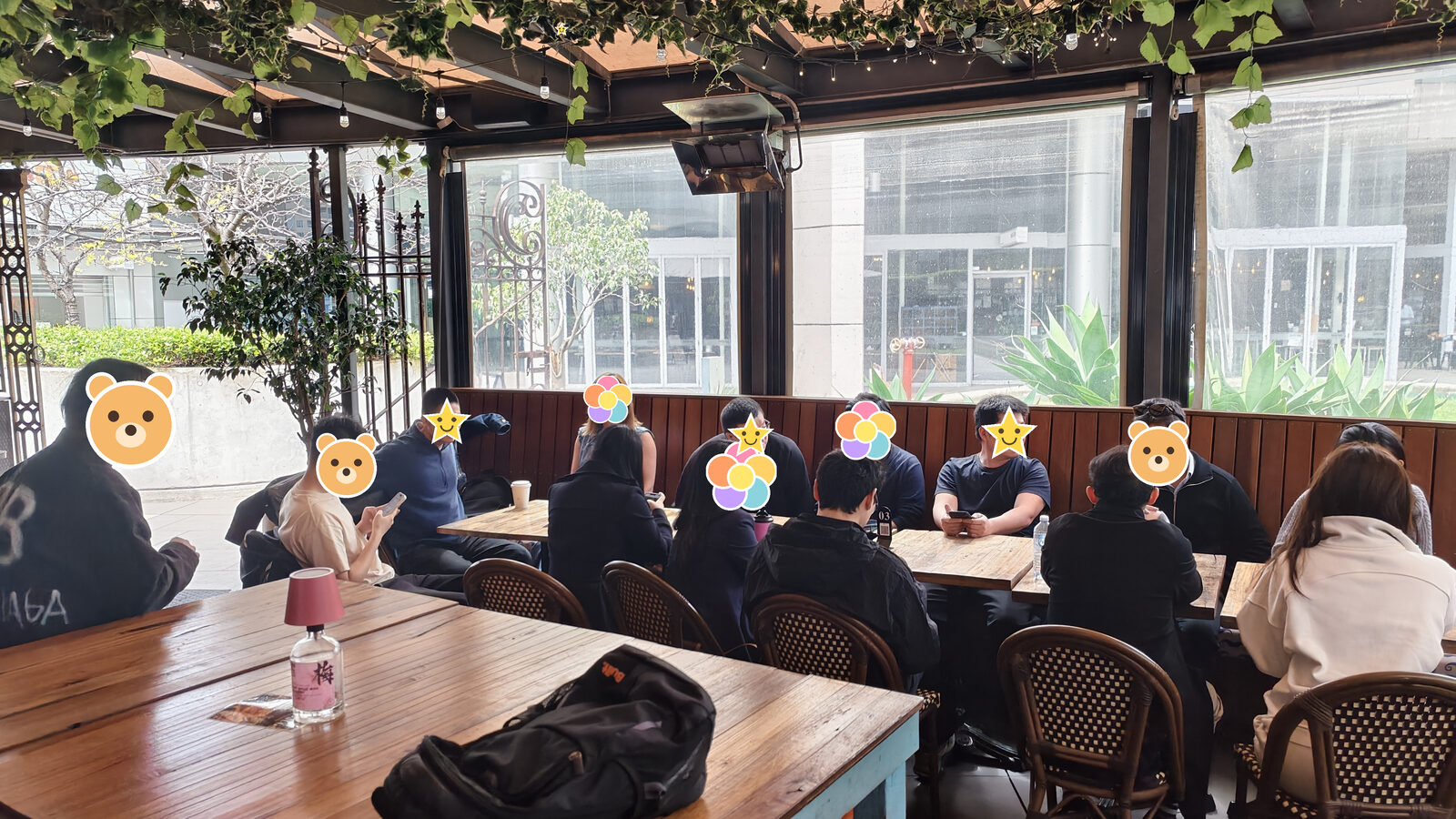 靠玻璃墙的长凳上坐了一排人，窗外是街和龙舌兰，前面的桌上放着一个背包